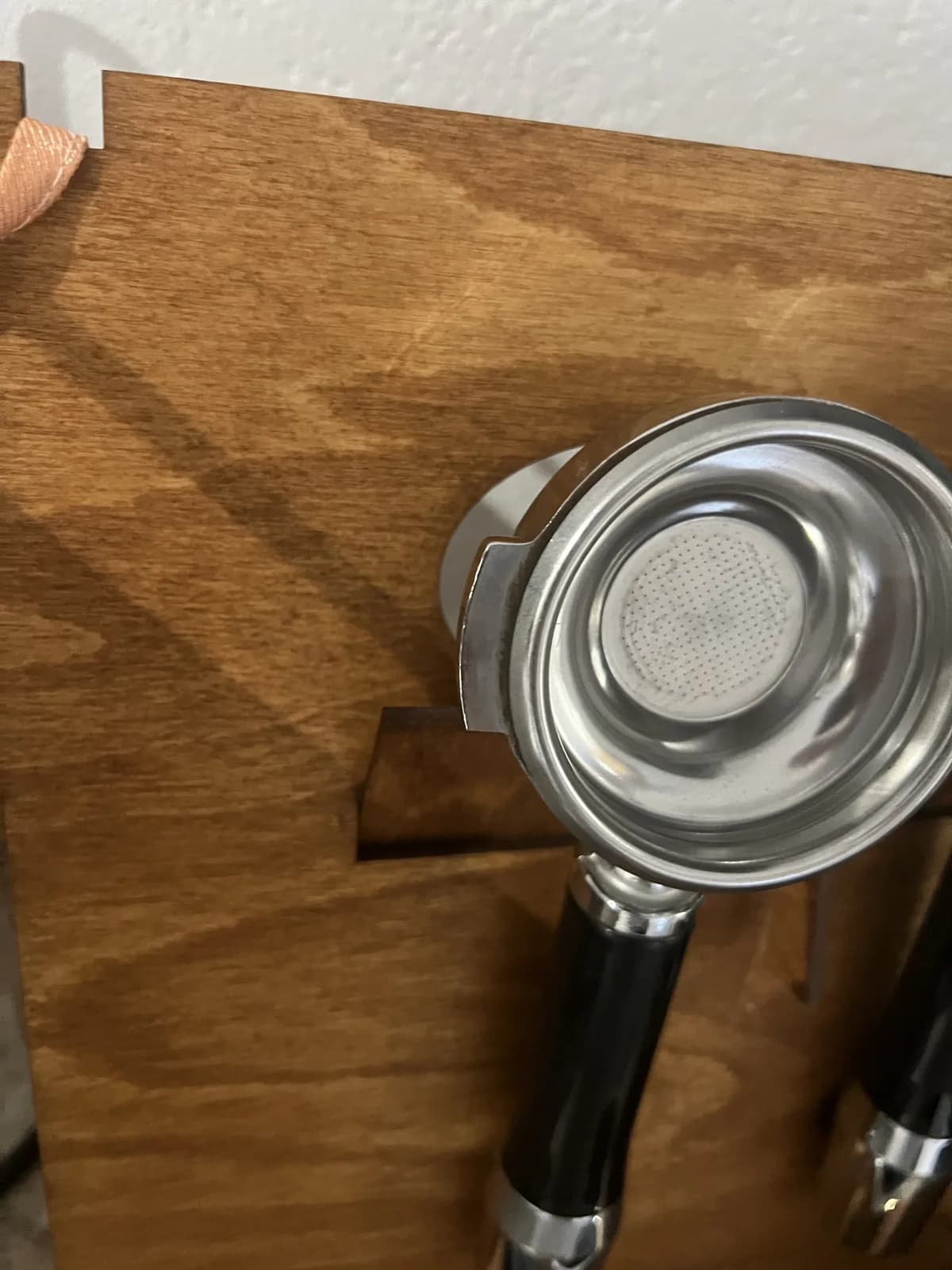 Primer plano: un portafiltros cuelga por sus orejas en el recorte del panel trasero