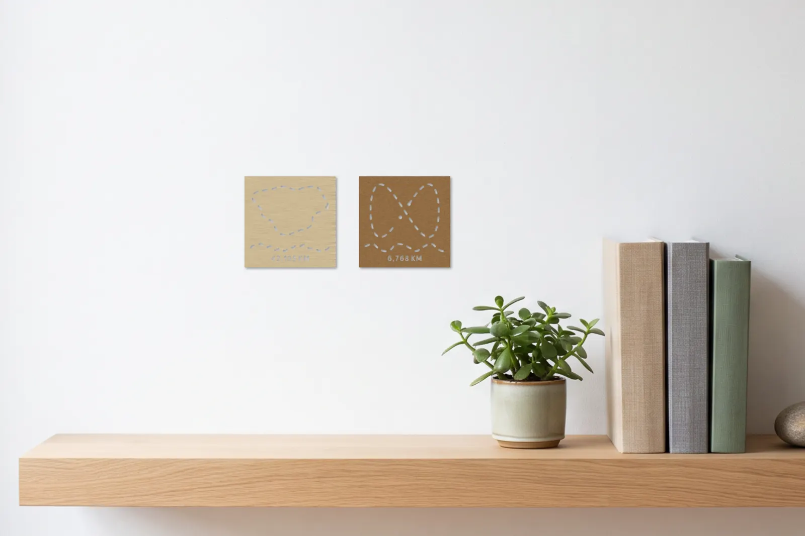 Dos pósteres de running pequeños sobre una estantería de pared con una planta y libros