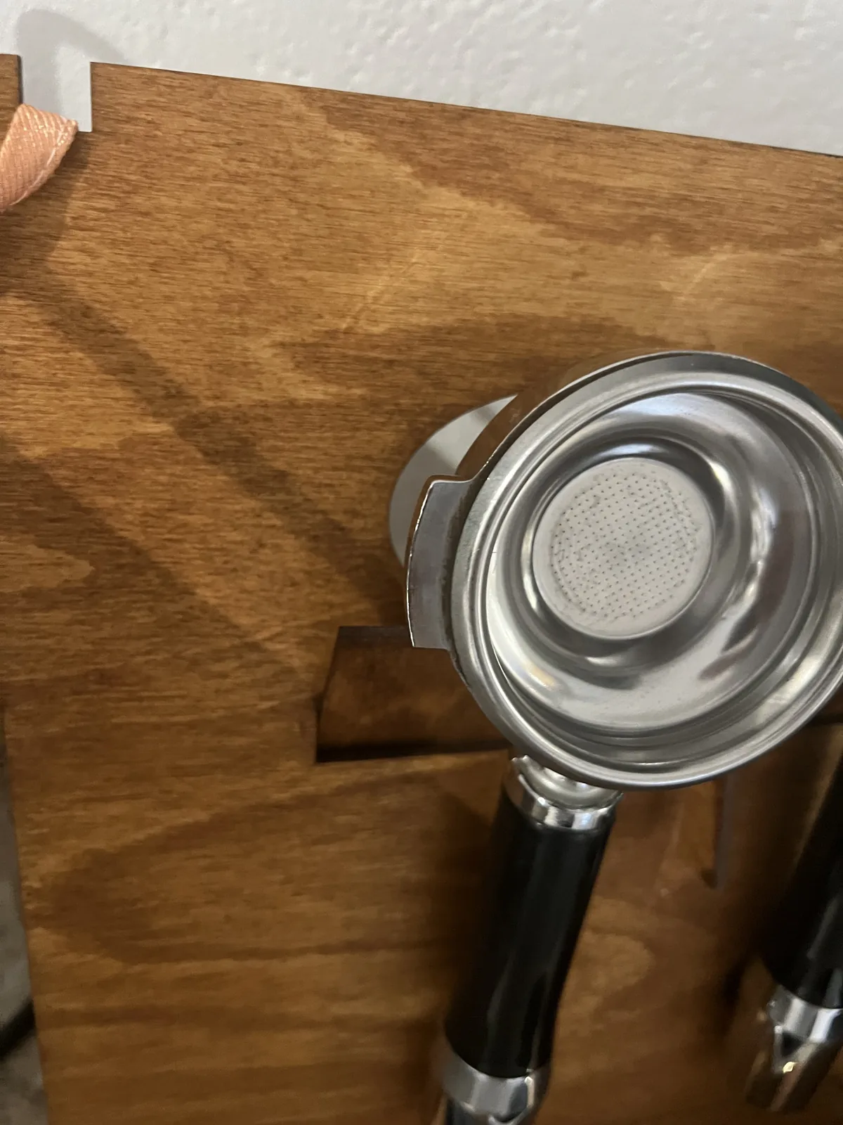 Primer plano: un portafiltros cuelga por sus orejas en el recorte del panel trasero
