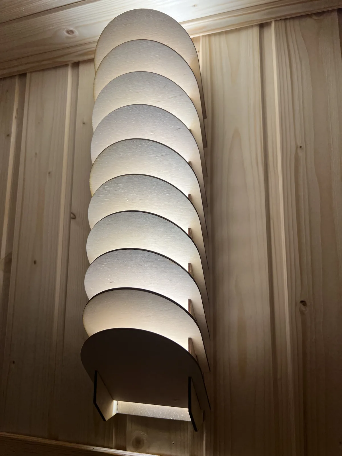 Die Lamellenlampe schräg von unten gesehen: der Stapel halbrunder Lamellen und darunter der geschlossene Sockel, der den LED-Streifen verdeckt
