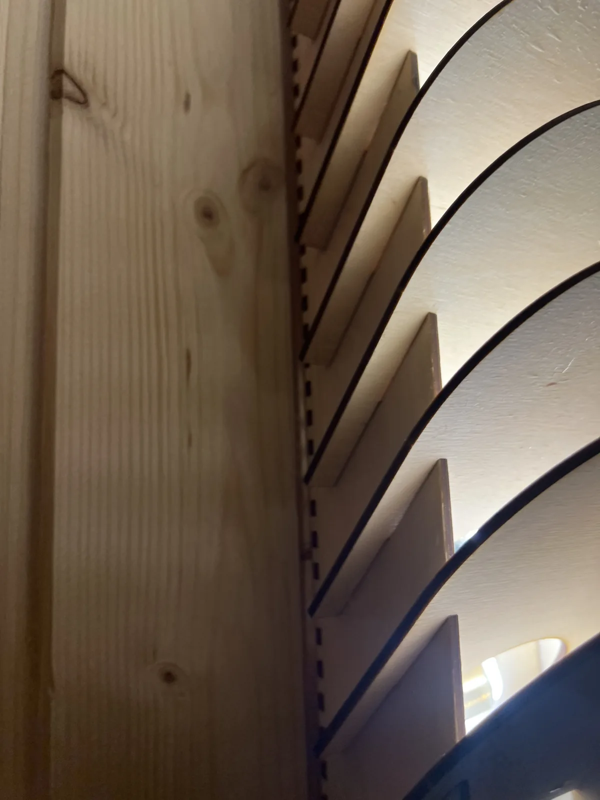 Nahaufnahme der Steckverbindung: eine Lamelle sitzt formschlüssig in einem Schlitz des Rückgrats, die Laserschnittkante ist dunkel gebrannt